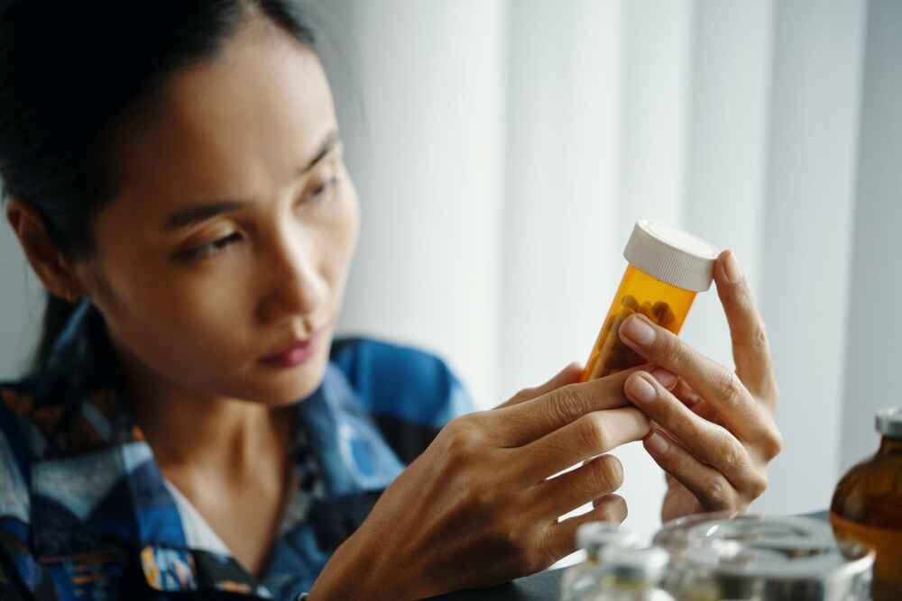 Woman checking for any drug allergies by checking medication ingredients