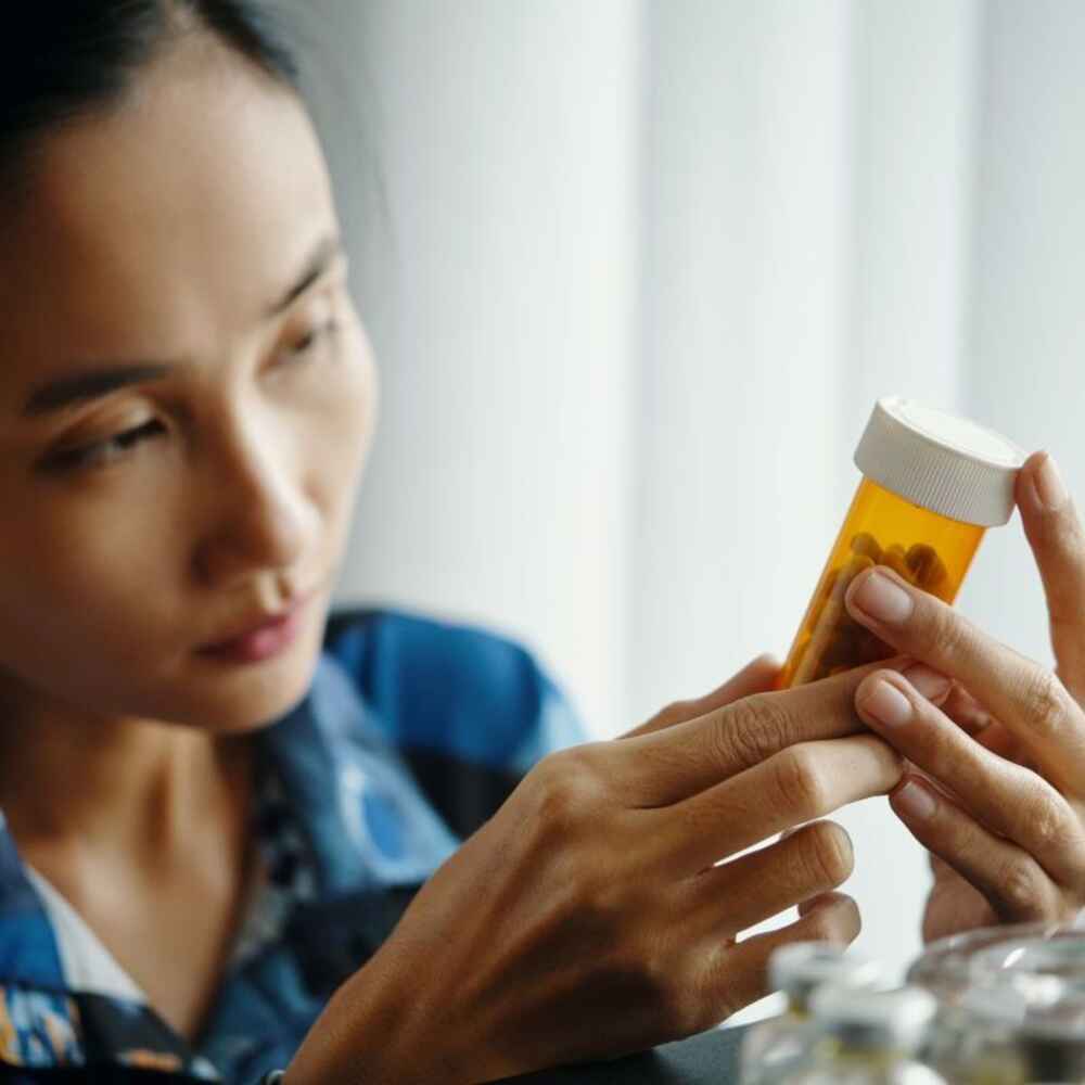 Woman checking for any drug allergies by checking medication ingredients