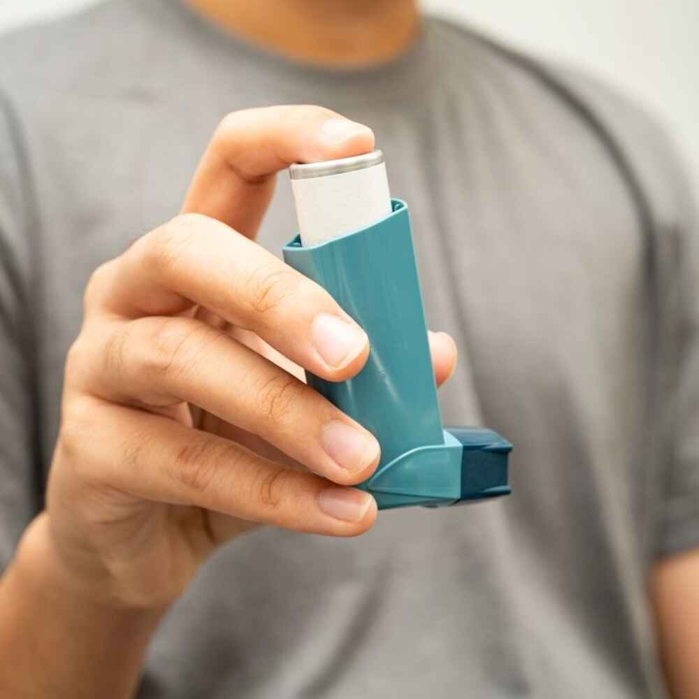Man holding an asthma inhaler