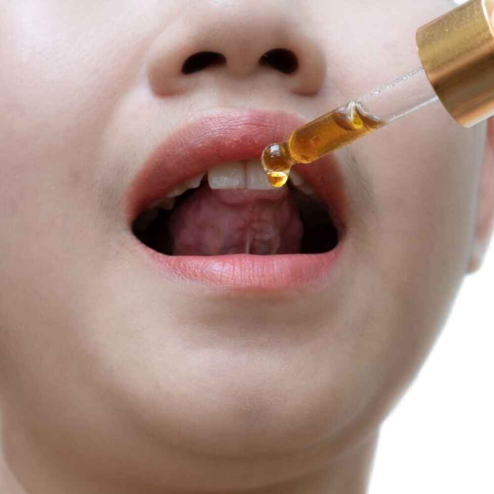 Woman using allergy drop under tongue