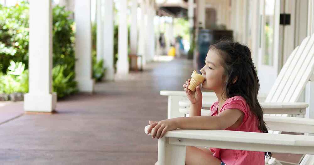 Little girl eating ice cream cone while being free of allergies