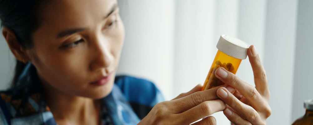Woman checking for any drug allergies by checking medication ingredients