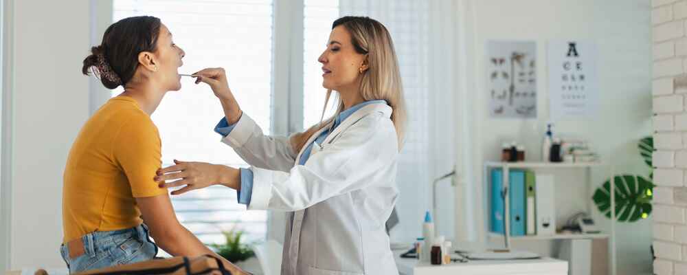 ENT doctor checking patient's mouth and throat
